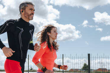 Paar joggt gegen bewölkten Himmel - EYF04705