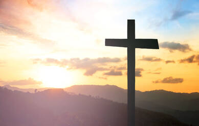 Silhouette Kreuz auf Berge gegen bewölkten Himmel bei Sonnenuntergang - EYF04806