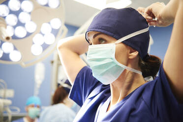 Low Angle View of Doctor Tying Chirurgische Maske im Krankenhaus - EYF04831