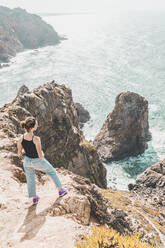 Portugal, Lissabon, Sintra, Junge Frau bewundert den Atlantik vom Rand der Klippen des Cabo da Roca - FVSF00133