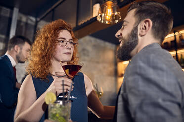 Couple with drinks talking in a bar - ZEDF03263