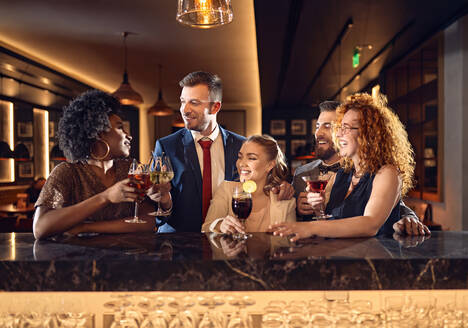 Glückliche Freunde, die sich in einer Bar bei Cocktails unterhalten - ZEDF03274