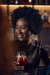 Porträt einer Frau, die einen Cocktail in einer Bar trinkt - ZEDF03282