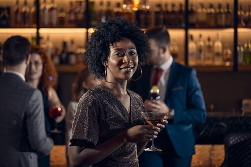 Porträt einer jungen Frau, die einen Cocktail in einer Bar trinkt - ZEDF03290