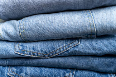 Stack of blue jeans, close-up - FMOF00968