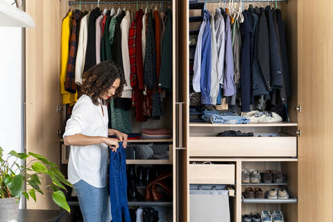 Woman clearing out her wardrobe stock photo