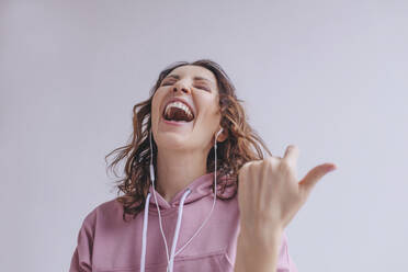 Brunette woman listening to music and singing - OGF00298