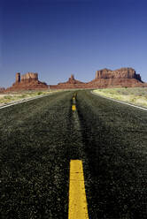 USA, Klarer Himmel über leerem Highway im Monument Valley - DSGF01930