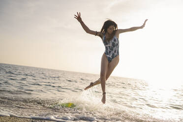 Young surfer jumping in the air at seashore, Almeria, Spain - MPPF00820