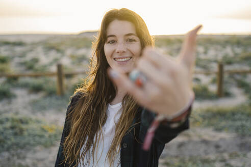 Portrait of smiling young woman showing shaka sign - MPPF00832