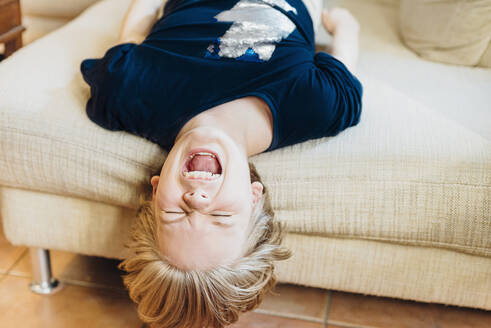 Screaming boy lying on couch - MJF02464