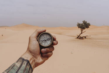 Hand hält Kompass in der Wüste - DAMF00344