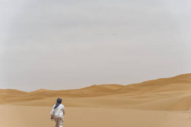 Mann beim Wandern in der Wüste von Merzouga, Marokko - DAMF00346