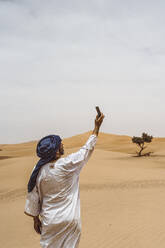 Man taking smartphone selfie in the desert - DAMF00351