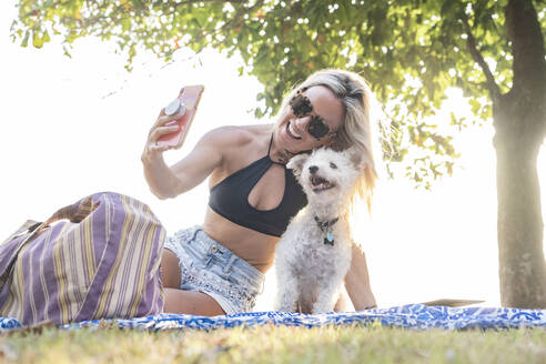 Schöne Frau macht ein Selfie mit ihrem Hund am Strand, Costa Rica - AMUF00050