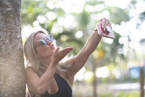 Schöne Frau macht ein Selfie vor einem Baum, Costa Rica - AMUF00065