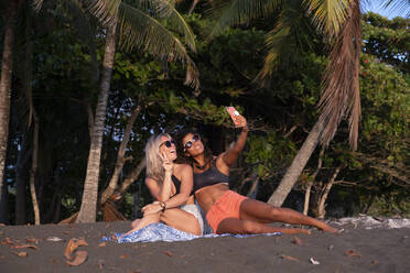 Zwei glückliche Frauen machen ein Selfie am Strand, Costa Rica - AMUF00066