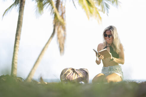 Schöne Frau liest ein Buch am Strand, Costa Rica - AMUF00067