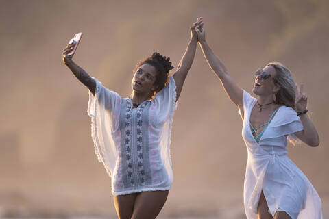 Two happy women taking selfie on the beach, Costa Rica stock photo