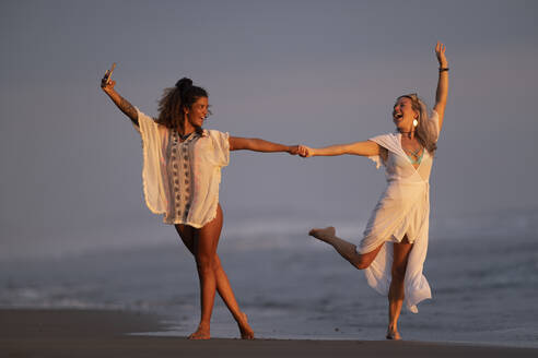Zwei glückliche Frauen machen ein Selfie am Strand, Costa Rica - AMUF00082