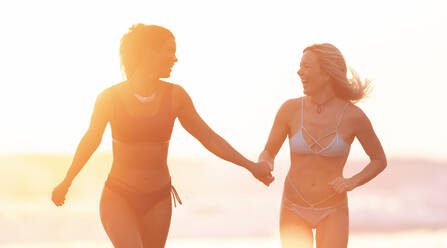 Zwei unbekümmerte Frauen am Strand bei Sonnenuntergang, Costa Rica - AMUF00085