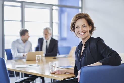 Porträt einer lächelnden Geschäftsfrau während einer Sitzung im Büro - RORF02108