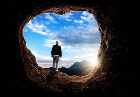 Rear View Of Man Standing In Cave Against Sky - EYF04834