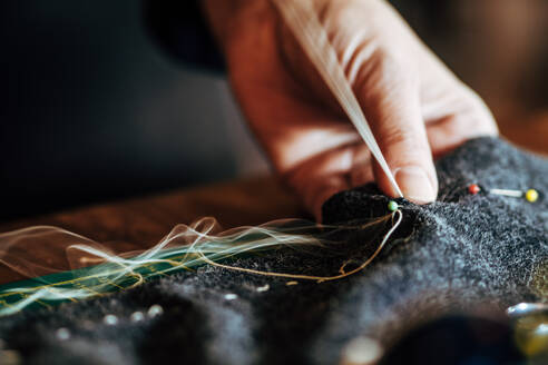 Nahaufnahme von Cropped Hand Sewing Textil in der Werkstatt - EYF04865