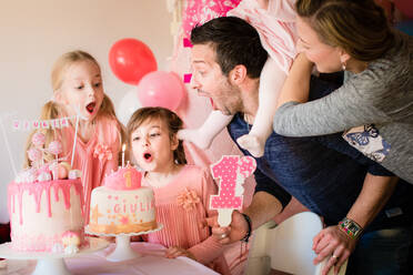Mother At Daughters Blowing Birthday Candle At Home - EYF04947