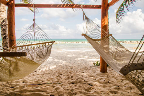 Hammocks Hanging On Beach Against Cloudy Sky - EYF04948