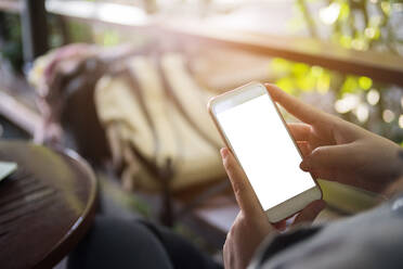 Cropped Hand Of Woman Using Mobile Phone In Balcony - EYF04974