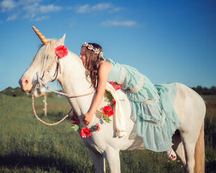 Mädchen reitet Pferd auf Feld - EYF04997