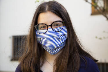 Teenager-Mädchen auf dem Weg zur Schule, mit Gesichtsmaske - LVF08819