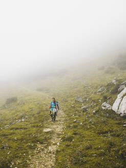 Spanien, Kantabrien, Weibliche Rucksacktouristin beim Wandern in den Picos de Europa bei nebligem Wetter - FVSF00156