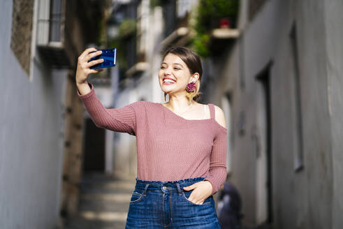 Glückliche Frau macht ein Selfie in der Stadt, Albaicin, Granada, Spanien - DGOF00821