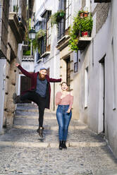 Carefree couple in an alley in the city, Albaicin, Granada, Spain - DGOF00822