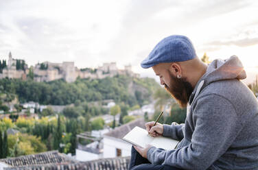 Man at observation point drawing a sketch of the Alhambra, Granada, Spain - DGOF00852