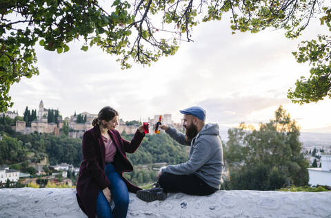 Coupleclinking drinks with Alhambra in background, Granada, Spain stock photo