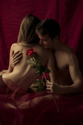 Intimate young couple with red rose stock photo