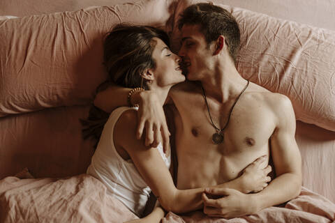 Intimate young couple lying in bed stock photo