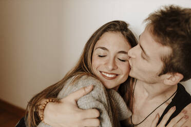 Happy young couple hugging and kissing at home - GMLF00067