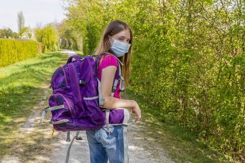 Girl on her way to school with protective mask stock photo
