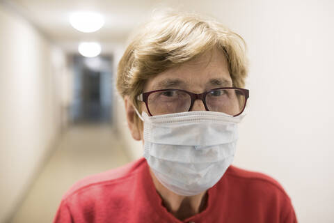 Senior woman with protective mask in corridor of retirement home stock photo