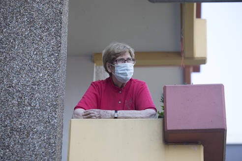 Senior woman wearing mask on balcony, retirement home - JATF01187