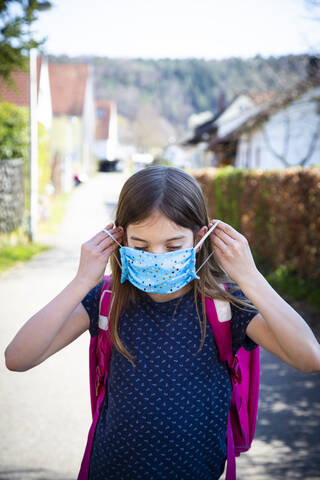 Girl with homemade protective mask on her way to school stock photo