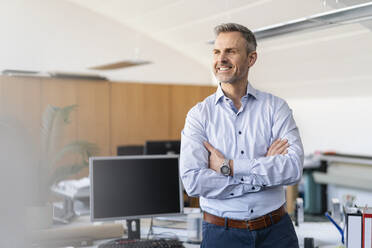 Portrait of smiling businessman in office - DIGF09681