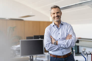 Portrait of smiling businessman in office - DIGF09682