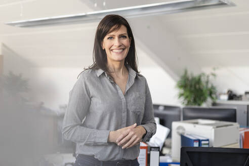 Portrait of smiling businesswoman in office - DIGF09684