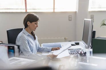 Businesswoman working at desk in office - DIGF09688