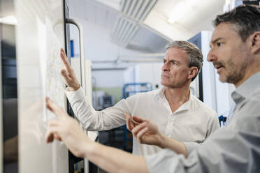 Businessmen in factory, having a meeting, discussing plans - DIGF09744